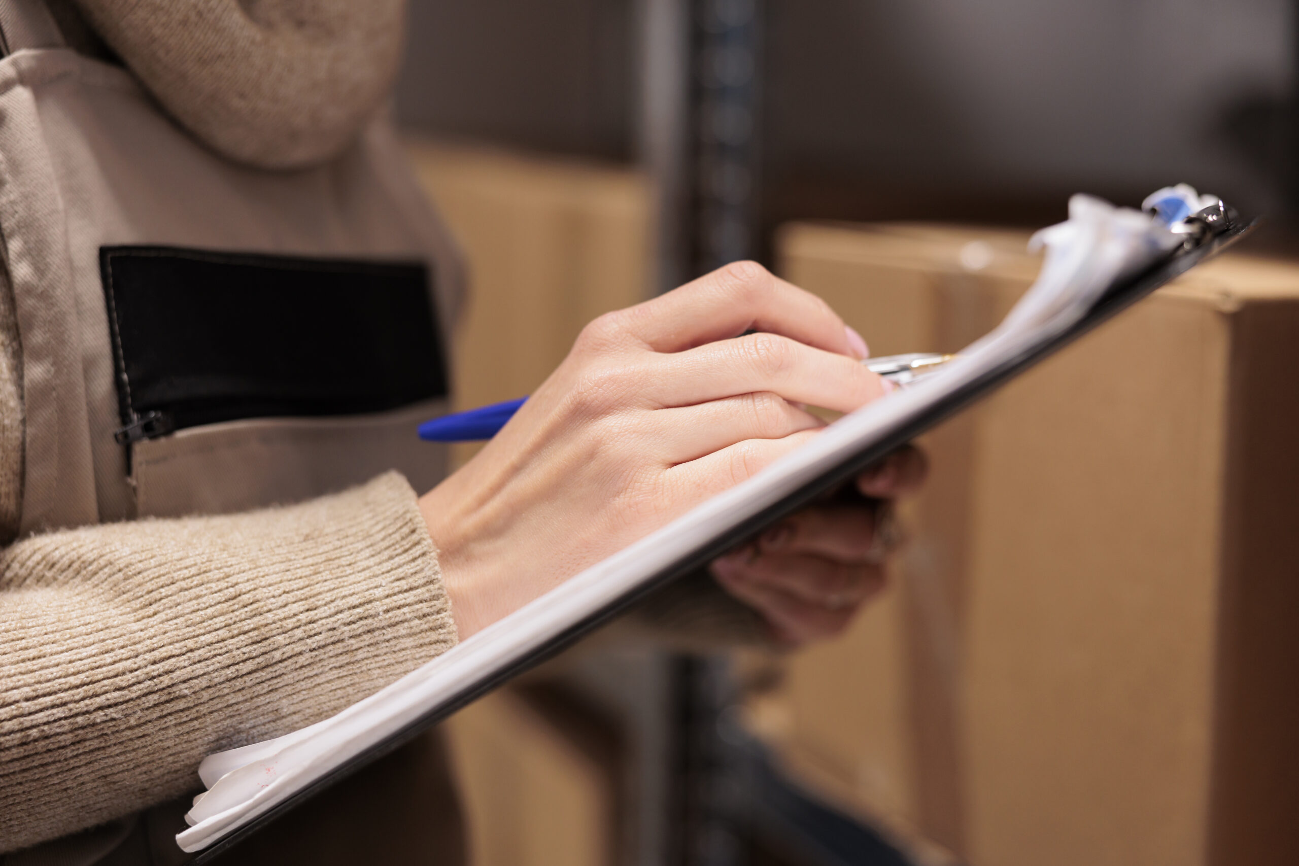 Servicios postal office storage worker holding clipboard in warehouse